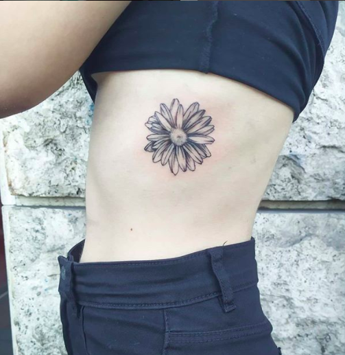 Micro-realistic daisy flower tattoo located on the