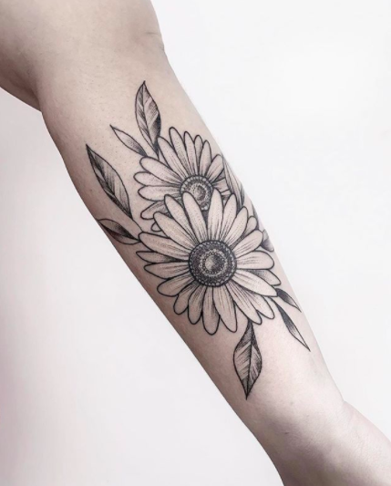 Daisy flowers tattoo located on the shoulder blade.
