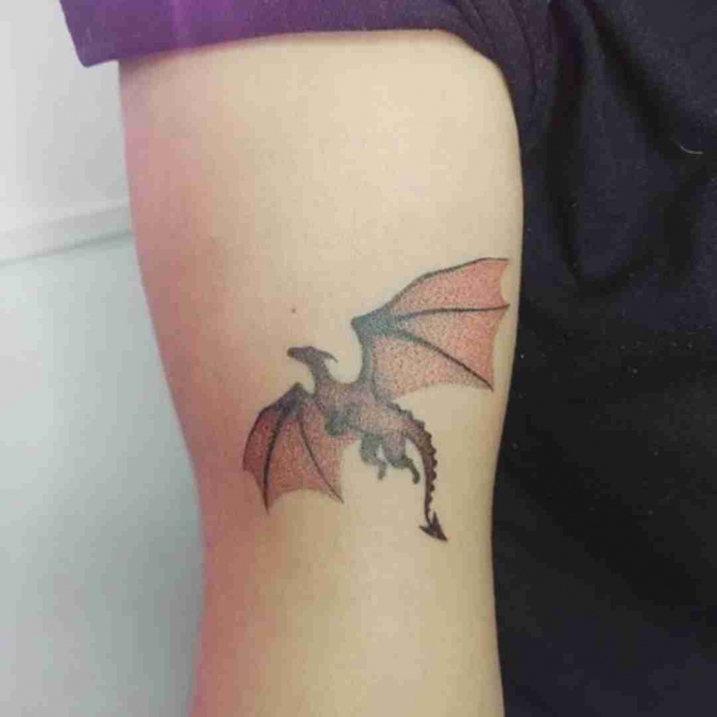 Tiny micro-realistic dragon tattoo located on the