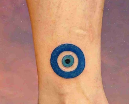 Blue evil eye tattoo by @eeriepeachtattoos